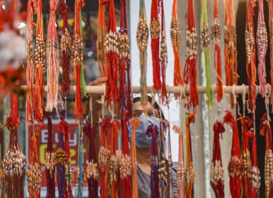 Mumbai: A woman looks at 'Rakhis' (sacred thread) at a roadside vendor ahead of the Hindu festival 'Raksha Bandhan' in Mumbai, Saturday, Aug. 21, 2021. (PTI Photo/Kunal Patil)