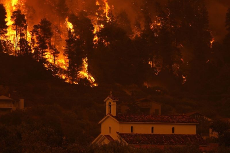 Flames approaching at Gouves village on the island of Evia, about 185 kilometers (115 miles) north of Athens, Greece on August 8, 2021. Pillars of billowing smoke and ash are blocking out the sun above Greece's second-largest island as a days-old wildfire devours pristine forests and triggers more evacuation alerts. (AP/PTI Photo)