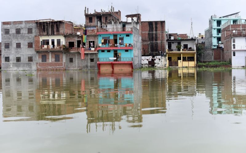 A view of houses submerged with risen water level of river Ganga following monsoon rain, at Chhota Baghara in Prayagraj on August 9, 2021. (PTI Photo)