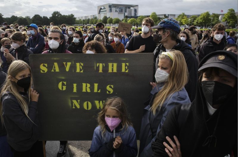 People hold a poster demanding the security of girls and people in Afghanistan during a demonstration in Berlin, Germany on August 17, 2021. Several hundreds of people attend a demonstration to support an air bridge to bring people out of the Taliban controlled country. (AP/PTI Photo)