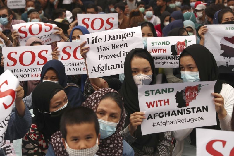 Afghan refugees  living in Indonesia hold posters during a rally outside the building that houses UNHCR representative office in Jakarta, Indonesia on Aug. 24, 2021. The protesters, mostly members of the Hazara ethnic minority, held the rally on Tuesday decrying the Taliban's takeover of their country and calling for resettlement in third countries. (AP/PTI Photo)