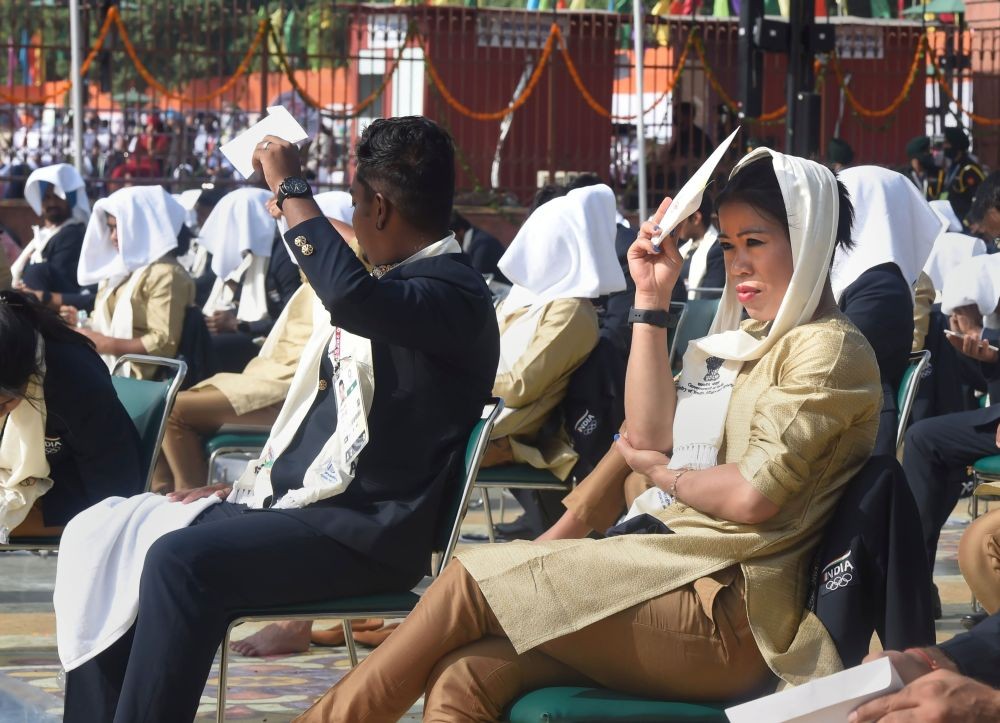 New Delhi: Tokyo Olympics 2020 participants cover their faces on a sunny day during the 75th Independence Day function at the historic Red Fort in New Delhi, Sunday, August 15, 2021. (PTI Photo/Kamal Singh)
