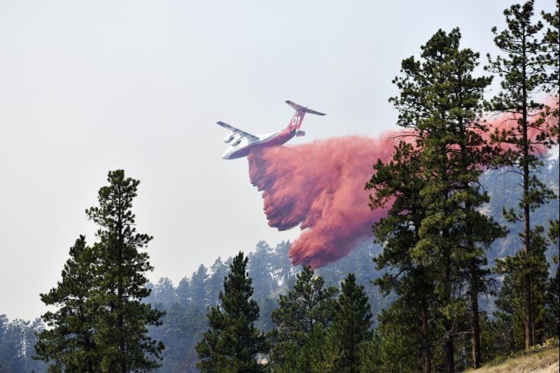 Lame Deer: An aircraft drops fire retardant to slow the spread of the Richard Spring fire, east of Lame Deer, Mont., Wednesday, Aug. 11, 2021. The fire spread quickly Wednesday as strong winds pushed the flames across rough, forested terrain. AP/PTI