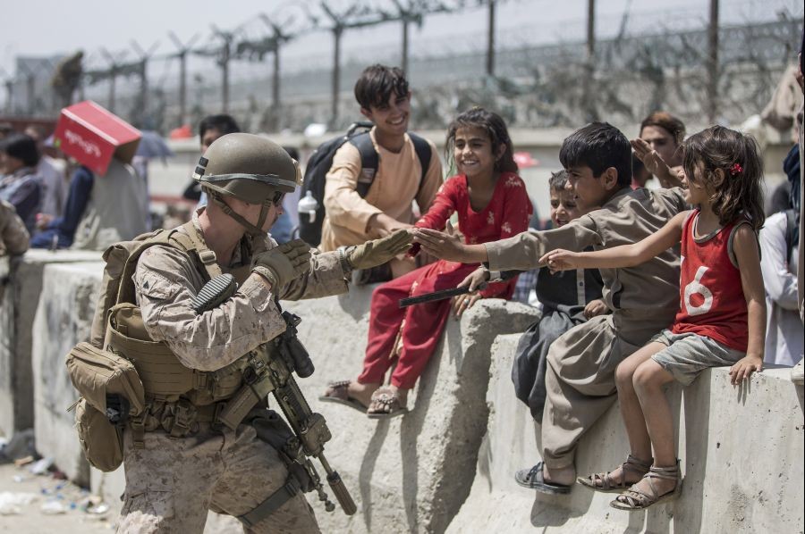 Kabul: In this image provided by the U.S. Marine Corps, a Marine with Special Purpose Marine Air-Ground Task Force-Crisis Response-Central Command (SPMAGTF-CR-CC) plays with children waiting to process during an evacuation at Hamid Karzai International Airport in Kabul, Afghanistan, Friday, Aug. 20, 2021.AP/PTI Photo