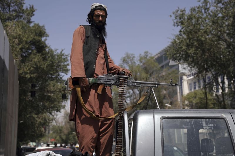 A Taliban fighter sits on the back of vehicle with a machine gun in front of the main gate leading to the Afghan presidential palace, in Kabul, Afghanistan on August 16, 2021. The U.S. military has taken over Afghanistan's airspace as it struggles to manage a chaotic evacuation after the Taliban rolled into the capital. (AP/PTI PHoto)
