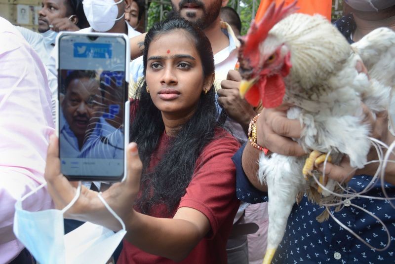 Shiv Sena's Yuva Sena activists stage a protest with a Rooster (Chicken) against BJP leader Narayan Rane, near Mantel Hospital in Thane on August 24, 2021. (PTI photo )