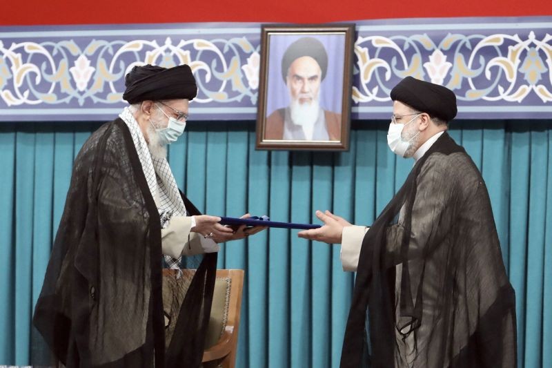 In this photo released by an official website of the office of the Iranian supreme leader, Supreme Leader Ayatollah Ali Khamenei, left, gives his official seal of approval to newly elected President Ebrahim Raisi in an endorsement ceremony in Tehran, Iran on August 3, 2021. A portrait of the late revolutionary founder Ayatollah Khomeini hangs in the background. (AP/PTI Photo)