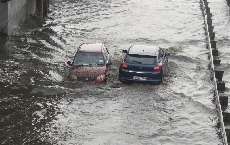 Gurugram: Vehicles wade through the waterlogged Delhi-Gurugram Expressway service road after heavy rains, at Narsinghpur in Gurugram, Sunday, August 8, 2021. (PTI Photo)