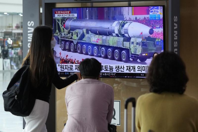 People watch a TV screen showing a file image of a North Korean missile in a military parade during a news program at the Seoul Railway Station in Seoul, South Korea on August 30, 2021. North Korea appears to have restarted the operation of its main nuclear reactor used to produce weapons fuels, the U.N. atomic agency said, as the North openly threatens to enlarge its nuclear arsenal amid long-dormant nuclear diplomacy with the United States. Korean letters read: "The reactor produces plutonium." (AP Photo)