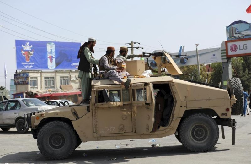 Taliban fighters stand guard in front of the Hamid Karzai International Airport, in Kabul, Afghanistan on August 16, 2021. Thousands of people packed into the Afghan capital's airport on Monday, rushing the tarmac and pushing onto planes in desperate attempts to flee the country after the Taliban overthrew the Western-backed government. (AP Photo)