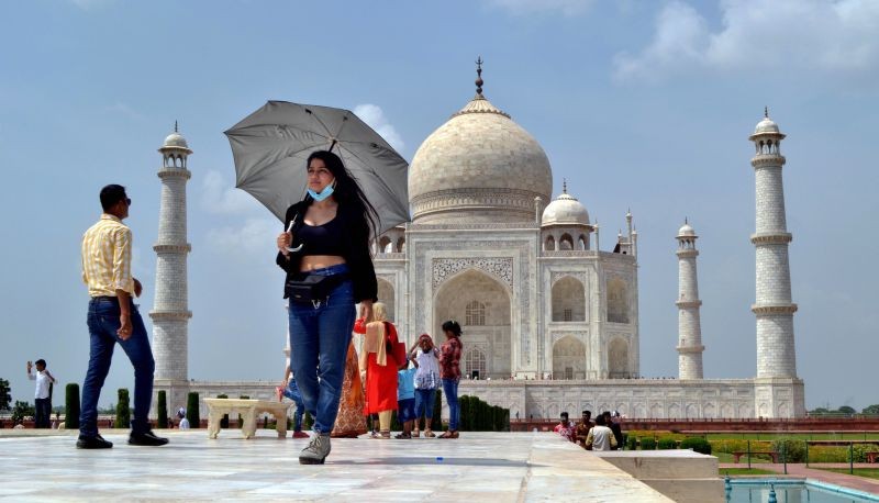 Agra: A woman carries an umbrella to avoid the scorching heat at Taj Mahal in Agra, Thursday, Aug 12, 2021. (PTI Photo)