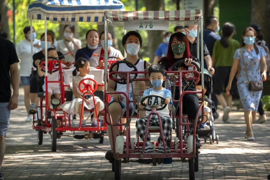 Beijing: Adults and children ride pedal cycles at a public park in Beijing, Saturday, Aug. 21, 2021. China will now allow couples to have a third child as the country seeks to hold off a demographic crisis that threatens its hopes of increased prosperity and global influence.AP/PTI Photo