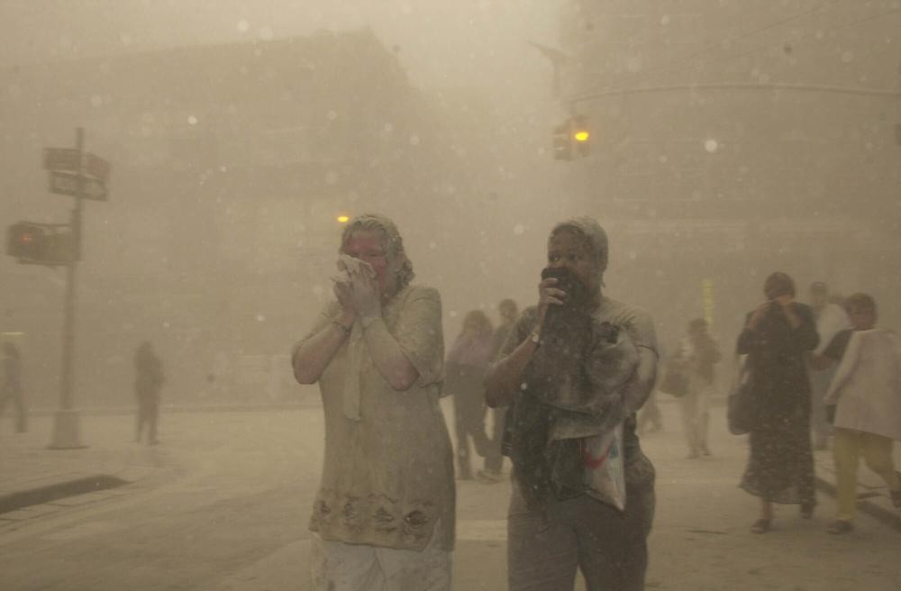 People run from the collapse of World Trade Center Tower Tuesday, Sept. 11, 2001 in New York. On that day, Howie Rumberg, working the overnight in AP Sports, came up out of a subway and found himself in the middle of chaos. (AP Photo/Suzanne Plunkett)