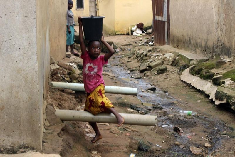 A girl carrying water on her head walks past sewage around houses in Abuja, Nigeria, Friday, Sept. 3, 2021. Nigeria is seeing one of its worst cholera outbreaks in years, with more than 2,300 people dying from suspected cases as the West African nation struggles to deal with multiple disease outbreaks. This year’s outbreak which is associated with a higher case fatality rate than the previous four years is also worsened by what many consider to be a bigger priority for state governments: the COVID-19 pandemic. (AP File Photo)