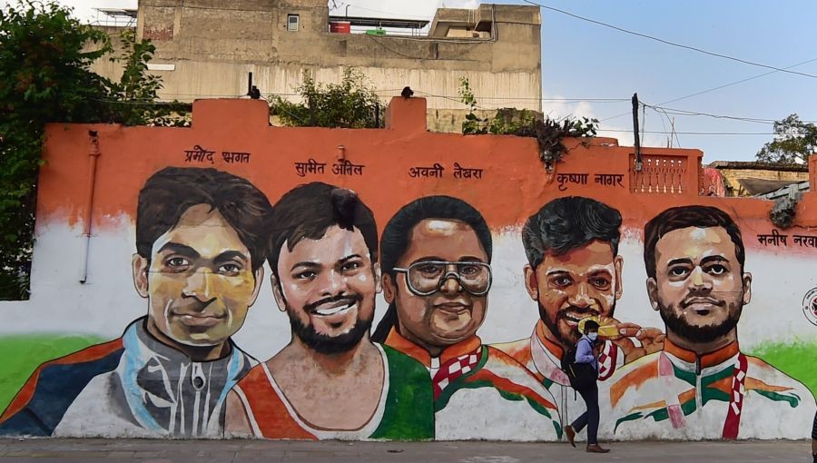 New Delhi: A man walks past a wall mural depicting Tokyo 2020 Paralympics medal winning athletes, in New Delhi, Monday, Sept. 20, 2021. (PTI Photo/Manvender Vashist)