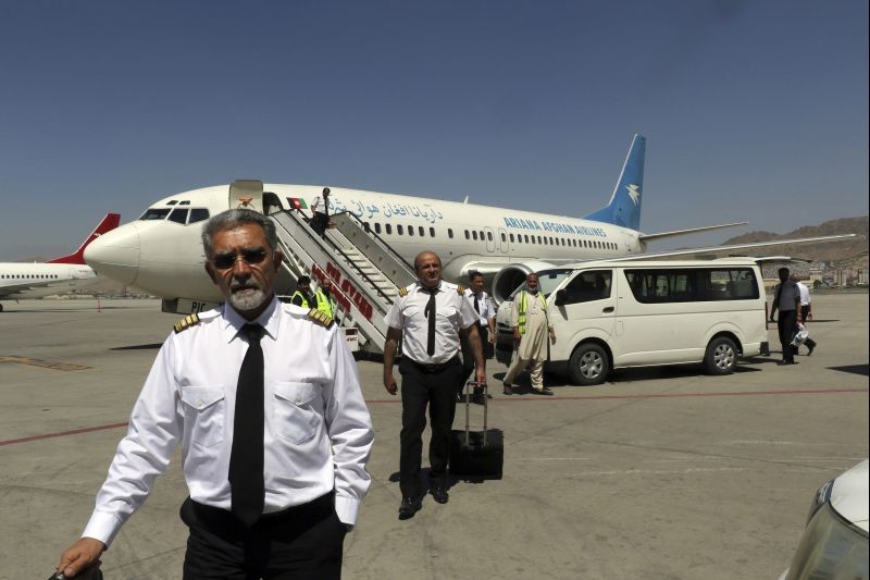 Pilots of Ariana Afghan Airlines walk on the tarmac after landing at Hamid Karzai International Airport in Kabul, Afghanistan on September 5, 2021. Some domestic flights have resumed at Kabul's airport, with the state-run Ariana Afghan Airlines operating flights to three provinces. (AP/PTI Photo)