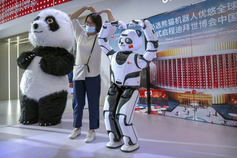 Beijing: A visitor poses for a photo with a robotic panda at a display from Chinese robot maker UBTech at the World Robot Conference in Beijing, Saturday, Sept. 11, 2021. The annual conference is a showcase of China's robot industry ranging from companion robots to those deployed on manufacturing assembly lines and entertainment. AP/PT