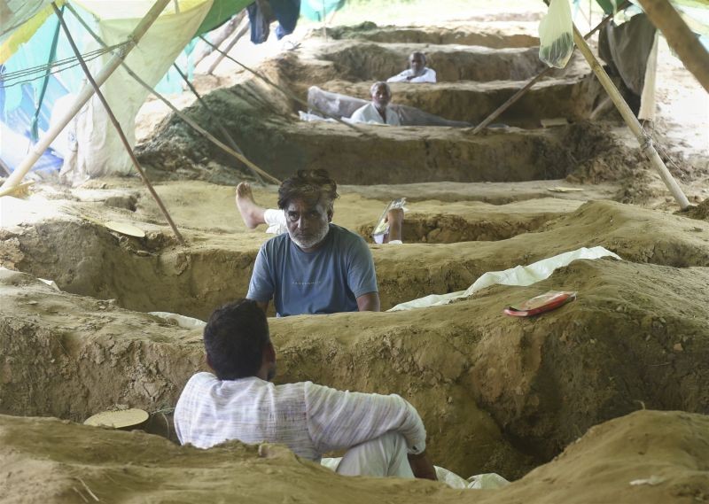 Farmers lie on pits during a protest against farm laws and compensation for their lands acquired under the UP Housing and Development Board’s (UPHDB) Mandola housing scheme, in Ghaziabad on September 26. Samyukta Kisan Morcha has called Monday (September 27) to be observed as 'Bharat Bandh'. (PTI Photo)