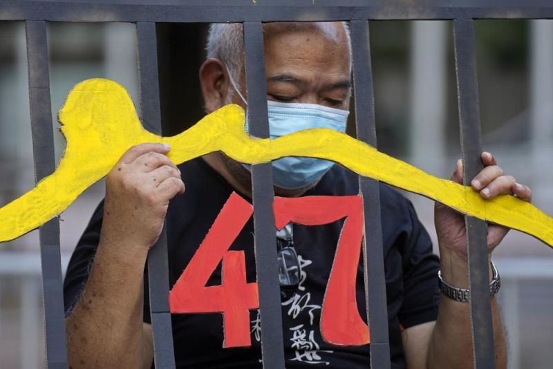 A protester stands behind a mock prison during a protest against an election committee that will vote for the city's leader in Hong Kong on September 19, 2021. Hong Kong's polls for an election committee that will vote for the city's leader kicked off Sunday amid heavy police presence, with chief executive Carrie Lam saying that it is "very meaningful" as it is the first election to take place following electoral reforms. (AP Photo)