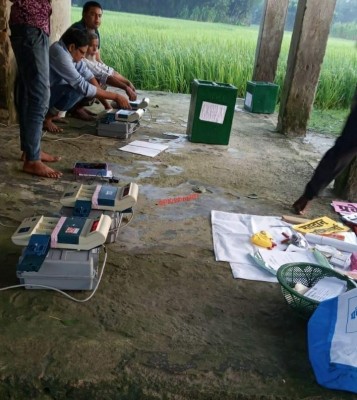 Officials forced to put EVMs, ballot boxes on the ground for polling in Araria. (IANS Photo)