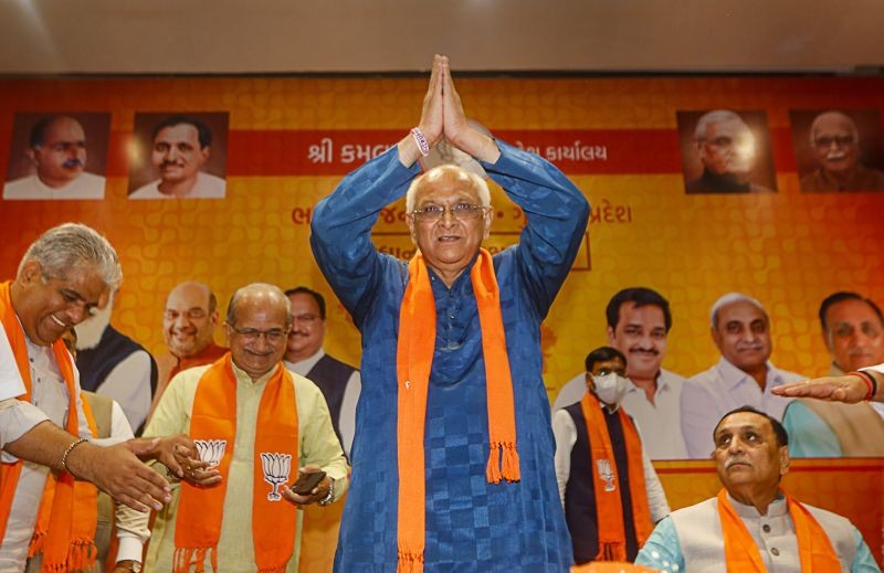 BJP leader Bhupendra Patel acknowledges the greeting after being appointed as new Gujarat Chief Minister, at party headquarters in Gandhinagar on September 12, 2021. Union Minister Bhupender Yadav and former Gujarat chief minister Vijay Rupani are also seen. (PTI Photo)