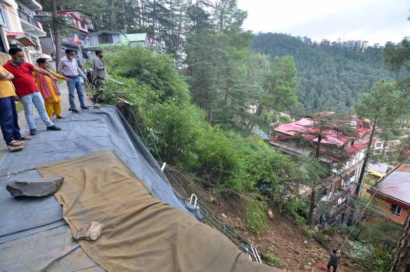 People stand on a damaged road after a landslide due to heavy rainfall, in Shimla on September 3, 2021. (PTI Photo)