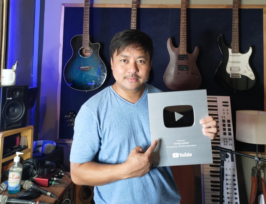 Sunep Lemtur posing with his Silver Creator Award  from YouTube for passing 100,000 subscribers.