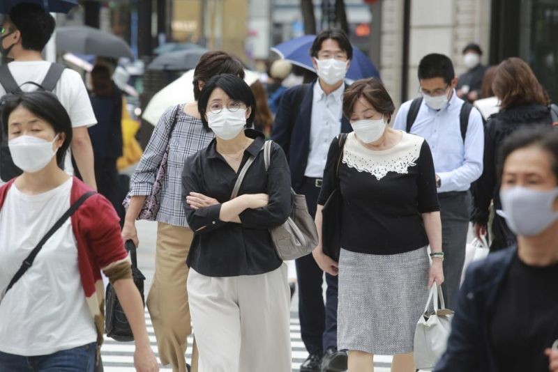 People wearing face masks to protect against the spread of the coronavirus walk on a street in Tokyo on September 8, 2021. (AP Photo)