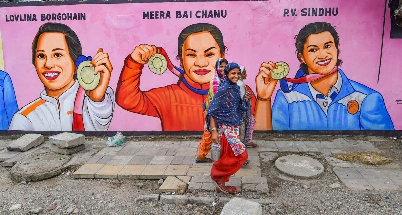 New Delhi: People walk past a wall graffiti, painted as Tokyo 2020 Olympics medal winners athletes, in New Delhi, Saturday, Sept. 18, 2021. (PTI Photo/Manvender Vashist)