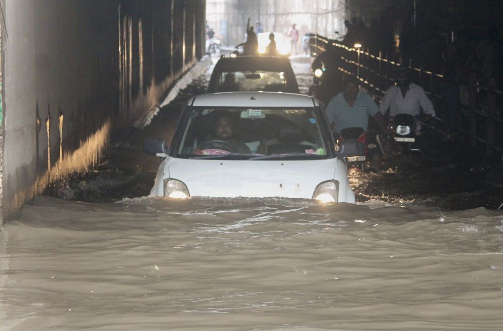 Faridabad: Commuters wade through a waterlogged area following heavy rains in Faridabad, Saturday, Sept. 11, 2021. (PTI Photo)(