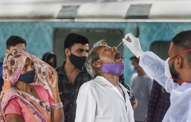 A health worker takes swab sample of a passenger for COVID-19 test, at a railway station in Mumbai on September 30, 2021. (PTI Photo)