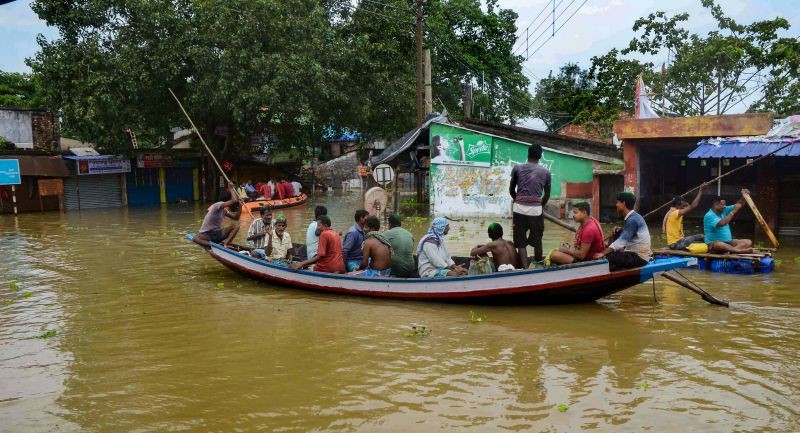 People use boats to travel at a flooded area at Amta in Howrah district on October 3, 2021. (PTI Photo)