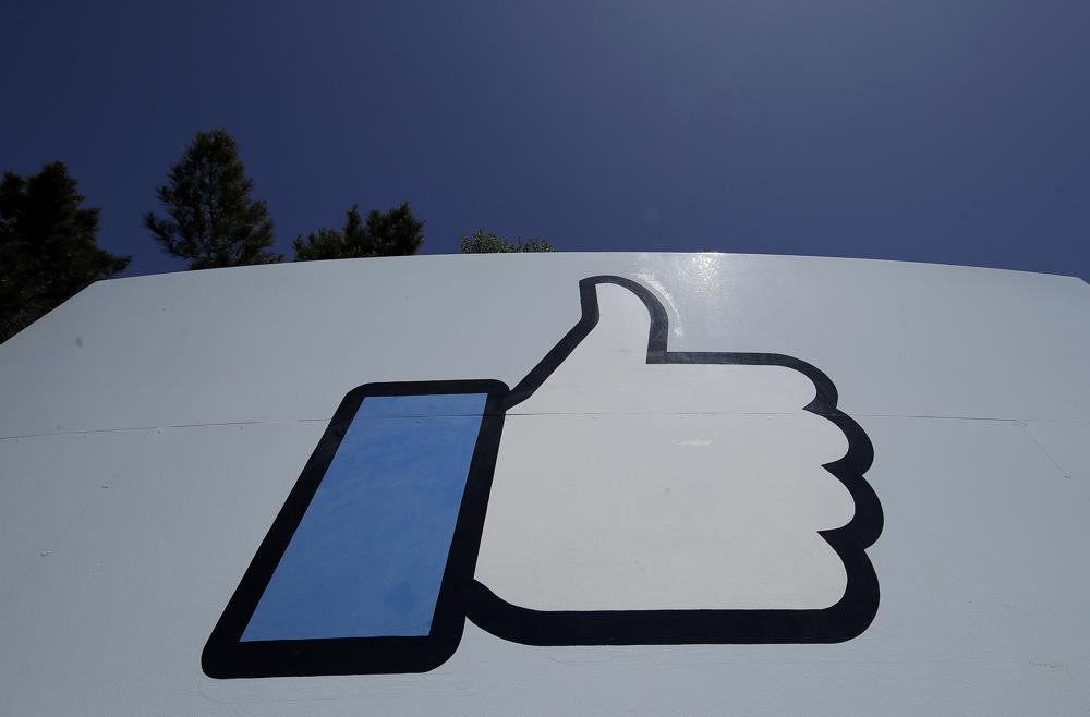 This April 25, 2019, file photo shows the thumbs-up "Like" logo on a sign at Facebook headquarters in Menlo Park, Calif. (AP Photo/Jeff Chiu, File)