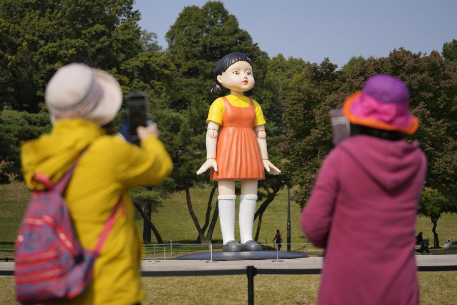 Seoul: Visitors take photos near a model of the doll named 'Younghee' that is featured in Netflix's series "Squid Game" displayed at the Olympic park in Seoul, South Korea, Tuesday, Oct. 26, 2021. AP/PTI