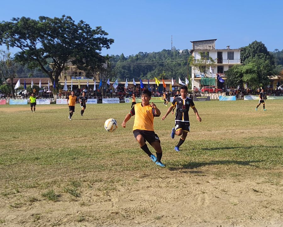 Players in action during the semi final match between Chümoukedima 'A' Village YO (orange jersey) and Medziphema Village YO (black jersey).
