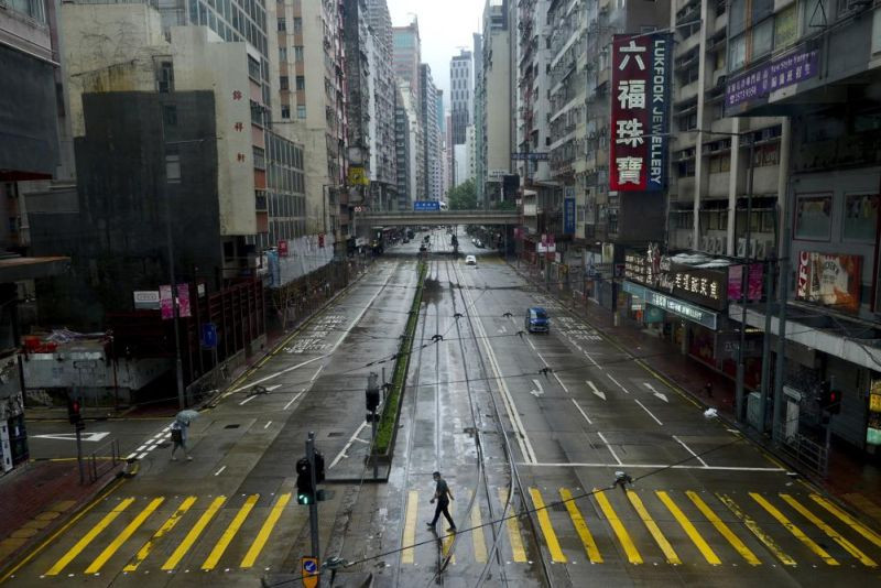 A man walks at an empty street as Typhoon Kompasu passes in Hong Kong on October 13, 2021. Hong Kong suspended classes, stock market trading and government services as the typhoon passed south of the city Wednesday. (AP Photo/)