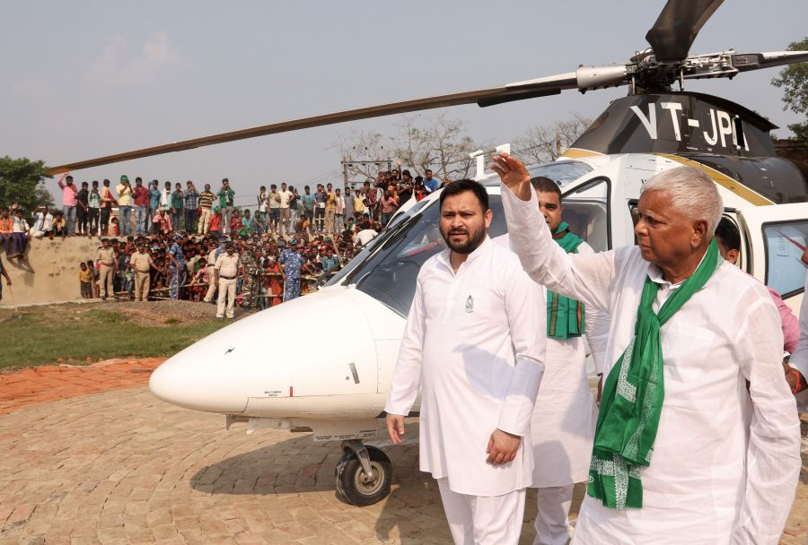 **EDS RPT CORRECTION LOCATION** Darbhanga:: Rashtriya Janata Dal (RJD) chief Lalu Prasad Yadav waves to supporters as son and party leader Tejashwi Yadav looks on, during a by-election campaign rally at Kusheshwar Asthan constituency in Darbhanga, Wednesday, Oct. 27, 2021. (PTI Photo)