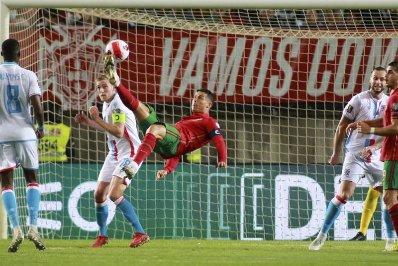 Portugal's Cristiano Ronaldo, center, attempt to score with an overhead kick during the World Cup 2022 group A qualifying soccer match between Portugal and Luxembourg at the Algarve stadium outside Faro, Portugal on October 12, 2021. (AP Photo)