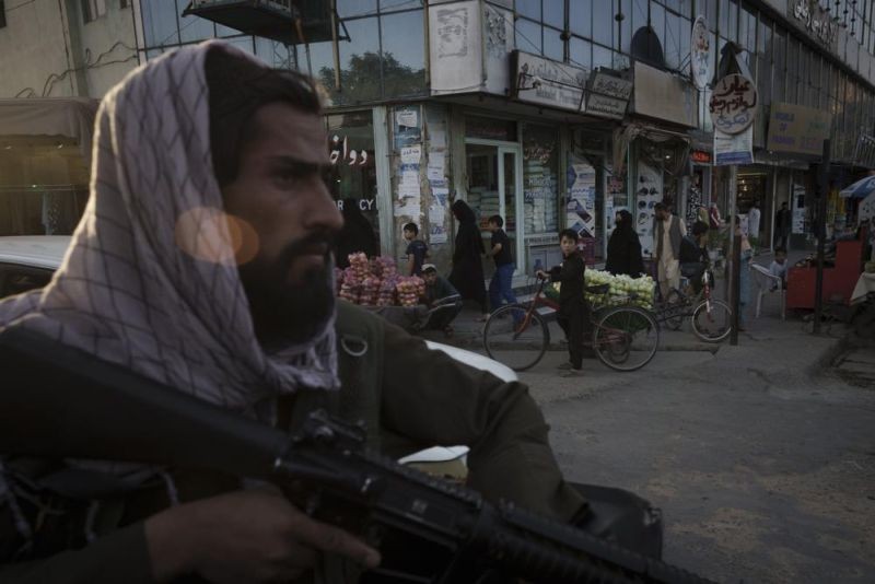 A boy looks as an Afghan fighter rides in the back of a vehicle during a police patrol in Kabul, Afghanistan, Tuesday, Sept. 14, 2021. The Taliban are promising a return of some of their harsh punishments that made them notorious. That has many Afghans afraid, but some also say they are giving the Taliban a chance if it means greater stability and fewer corrupt officials reaching into their pockets. (AP File Photo)