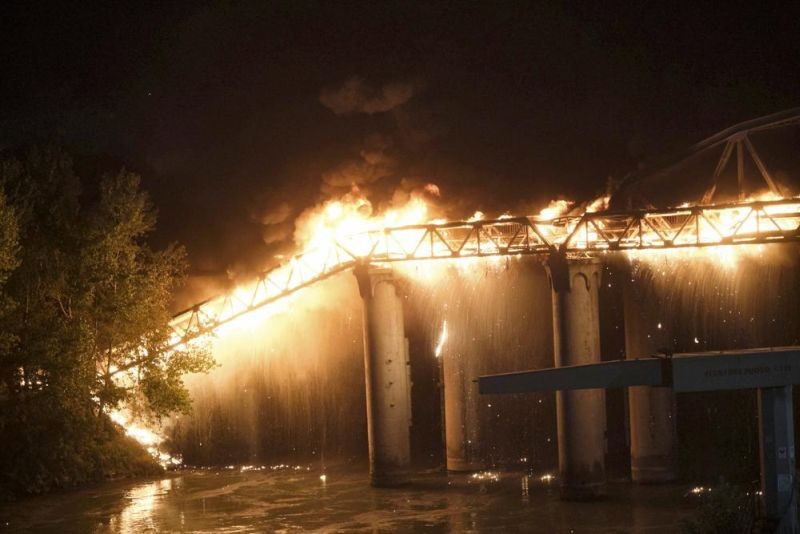 Flames engulf the Industry Bridge in Rome, early Sunday, Oct. 3, 2021. A blaze, possibly sparked by a gas canister explosion, destroyed part of an historic bridge spanning the Tiber River in Rome before firefighters extinguished the flames early Sunday. (AP Photo)