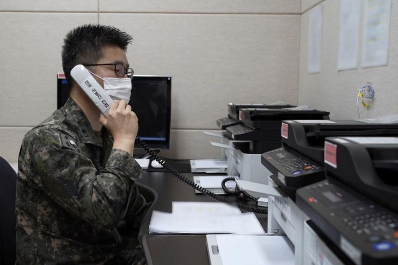 In this photo provided by South Korean Defense Ministry, an unidentified South Korean military officer makes a test call with a North Korean officer through an inter-Koran military communication line at an undisclosed location near the demilitarized zone, South Korea, Monday, Oct. 4, 2021. North Korea restored dormant communication hotlines with South Korea in a small, fragile reconciliation step Monday in an apparent hard push to win outside concessions with a mix of conciliatory gestures and missile tests. (AP Photo)