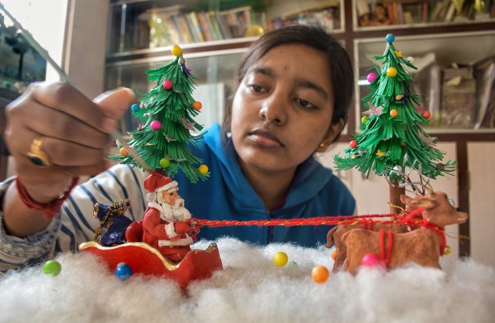 Nadia: Isha Sarkar, a student, makes miniature Santa Claus and sleigh at her home for the upcoming Christmas festival, in Nadia, Thursday, Dec. 23, 2021. (PTI Photo)