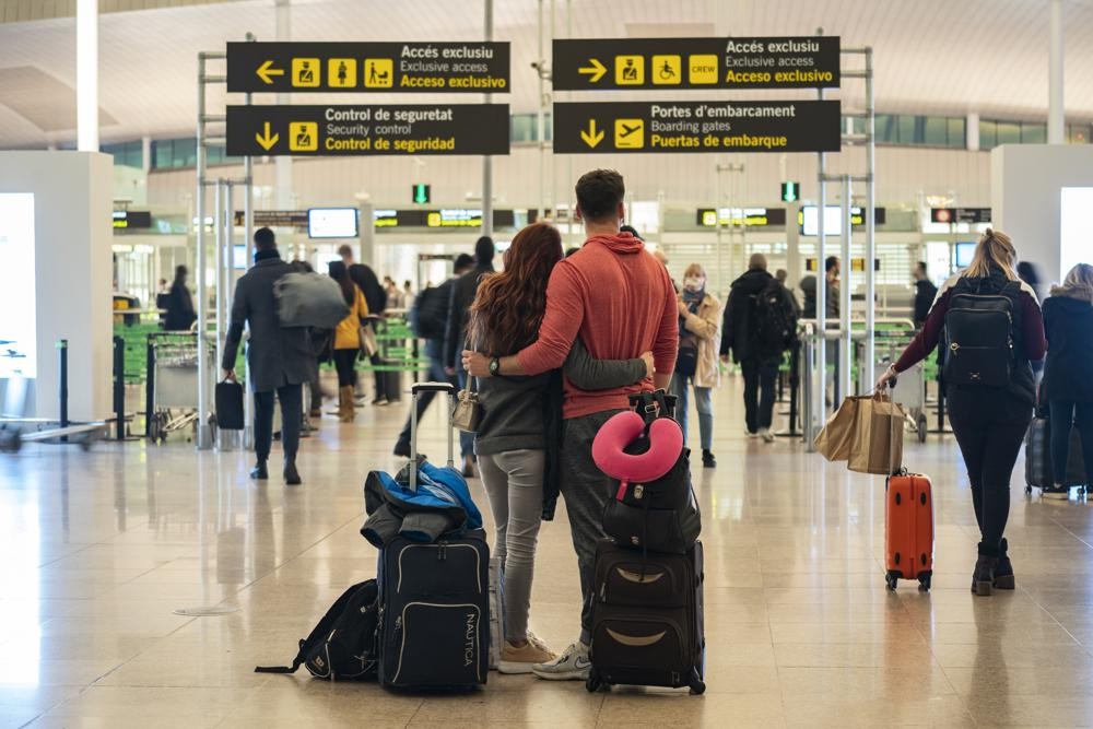 A couple stand outside the security control section inside a terminal of the Barcelona Airport, Wednesday, Dec. 1, 2021. Health authorities in the Spanish capital have confirmed a second case of the omicron coronavirus variant in a 61-year-old woman who had returned from a trip to South Africa on Monday. Meanwhile lines have returned for those seeking vaccine shots in Portugal and Spain as they step up efforts to close the gap of the few residents still unvaccinated. (AP Photo/Joan Mateu Parra)