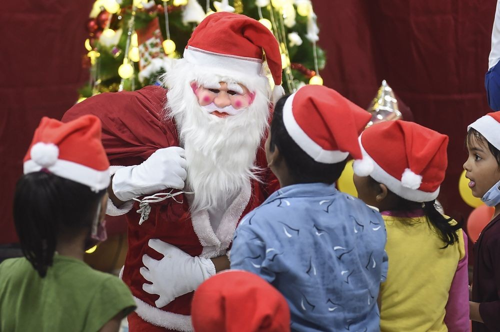 Mumbai: A man dressed as Santa Claus distribute sweets and toys mong children during Christmas celebrations at Bai Jerbai Wadia Hospital, in Mumbai, Saturday, Dec. 25, 2021.  (PTI Photo/Kunal Patil)