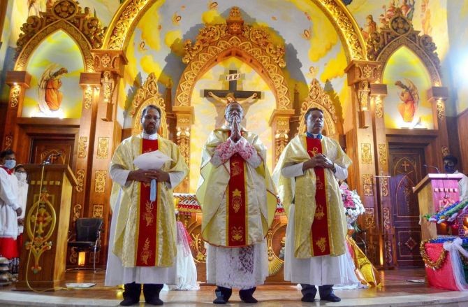 Archbishop A A S Durairaj, centre, conducts Christmas eve Mass at St Joseph Church, at BHEL in Bhopal, on Friday, December 24, 2021. Photograph: PTI Photo