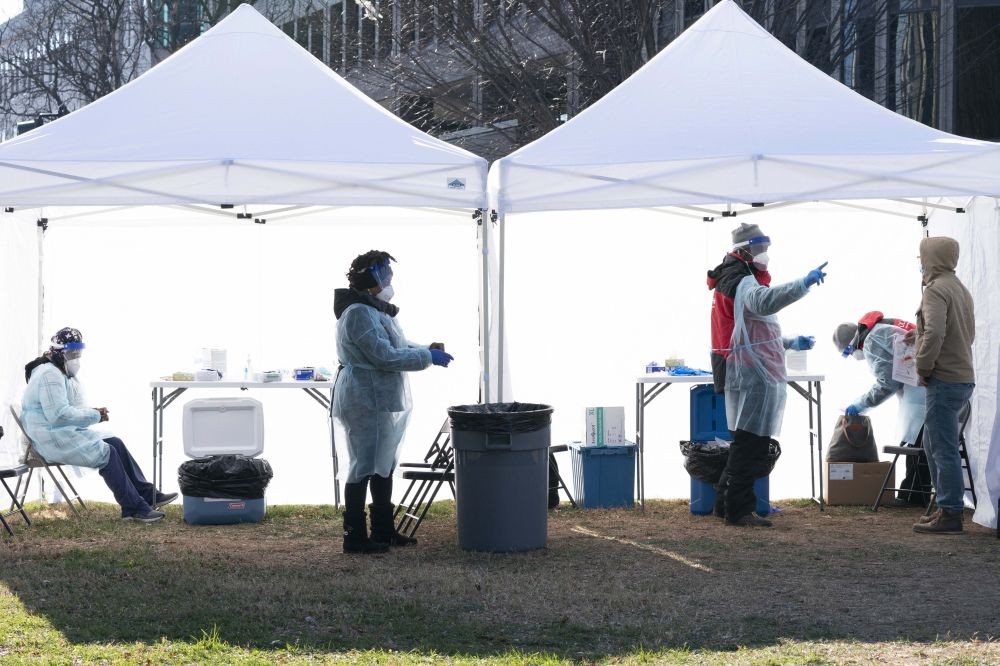 Washington: Workers, left, change their medical gloves as people are tested for COVID-19 at a walk-up testing site at Farragut Square, Thursday, Dec. 23, 2021, just blocks from the White House in Washington. The worldwide surge in coronavirus cases driven by the new omicron variant is the latest blow to hospitals, police departments, supermarkets and other critical operations struggling to maintain a full contingent of front-line workers as the pandemic enters its third year.AP/PTI