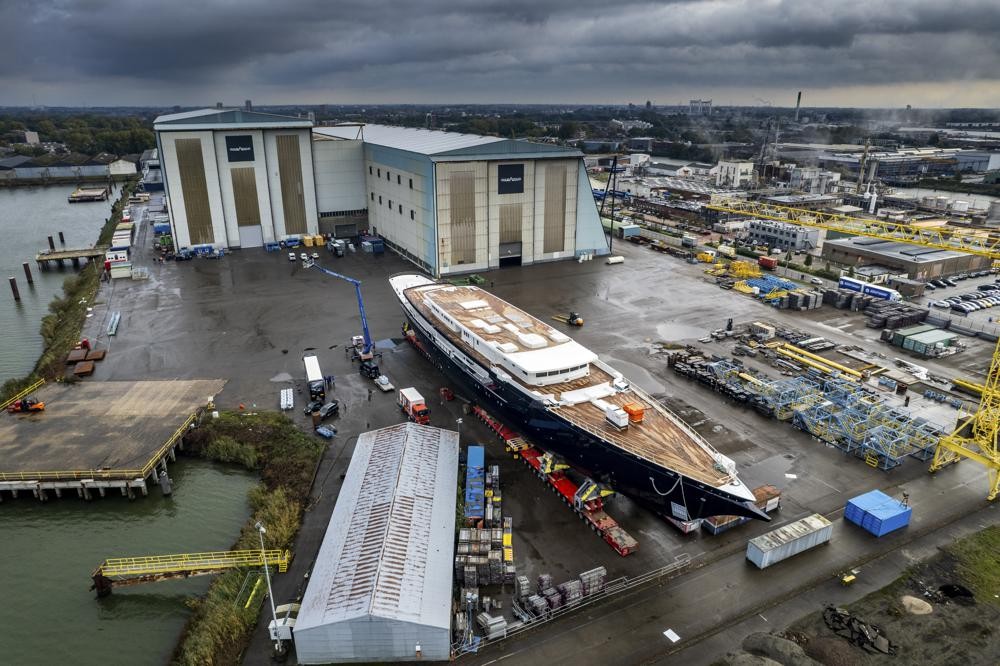 View of a yacht, reportedly being built for Amazon founder Jeff Bezos, on the wharf in Zwijndrecht, near Rotterdam, Netherlands, Wednesday, Oct. 21, 2021. A plan to dismantle a historic bridge in the heart of Dutch port city Rotterdam so that the huge yacht can get to the North Sea is unlikely to be plain sailing. Reports this week that the city had already agreed to take apart the recently restored Koningshaven Bridge, known locally as De Hef sparked anger in the city, with one Facebook group set up calling for people to pelt the multimillion dollar yacht with rotten eggs. (AP Photo/Guy Fleury)