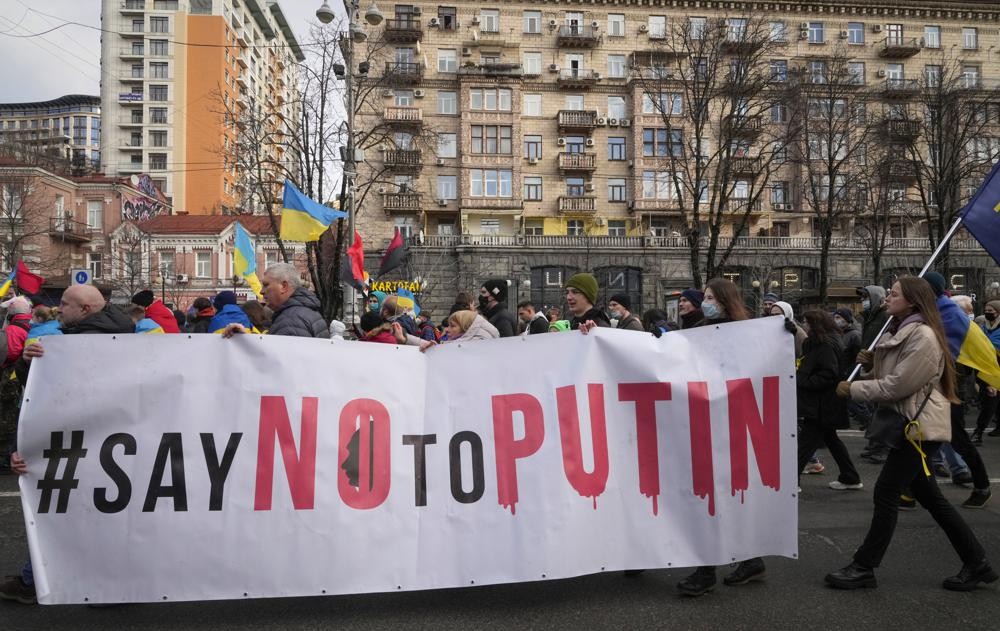 Ukrainians attend a rally in central Kyiv, Ukraine, Saturday, Feb. 12, 2022, during a protest against the potential escalation of the tension between Russia and Ukraine. Russian President Vladimir Putin and U.S. President Joe Biden are to hold a high-stakes telephone call on Saturday as tensions over a possibility imminent invasion of Ukraine escalated sharply and the U.S. announced plans to evacuate its embassy in the Ukrainian capital. (AP Photo/Efrem Lukatsky)