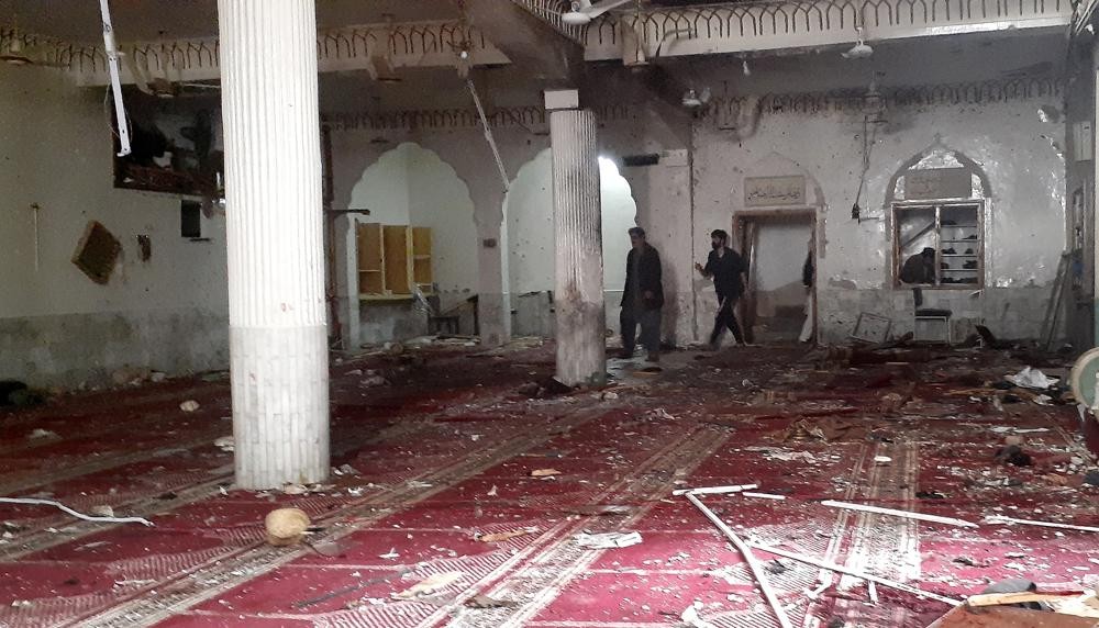 Volunteers examine the site of explosion inside a Shiite mosque in Peshawar, Pakistan, Friday, March 4, 2022. A powerful bomb exploded inside a Shiite Muslim mosque in Pakistan's northwestern city of Peshawar on Friday, killing more than 30 worshippers and wounding dozens more, many of them critically, police said. (AP Photo/Muhammad Sajjad)