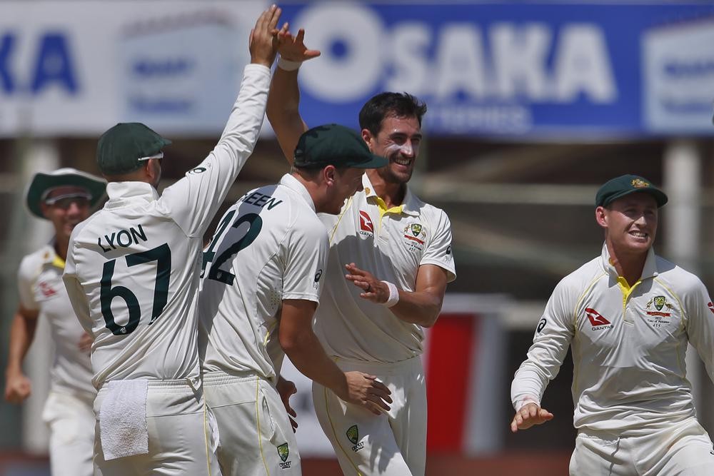 Australia's Mitchell Starc, second left, celebrates with teammates after taking the wicket of Pakistan Fawad Alam during the third day of the second test match between Pakistan and Australia at the National Stadium in Karachi, Pakistan, Monday, March 14, 2022. (AP Photo/Anjum Naveed)